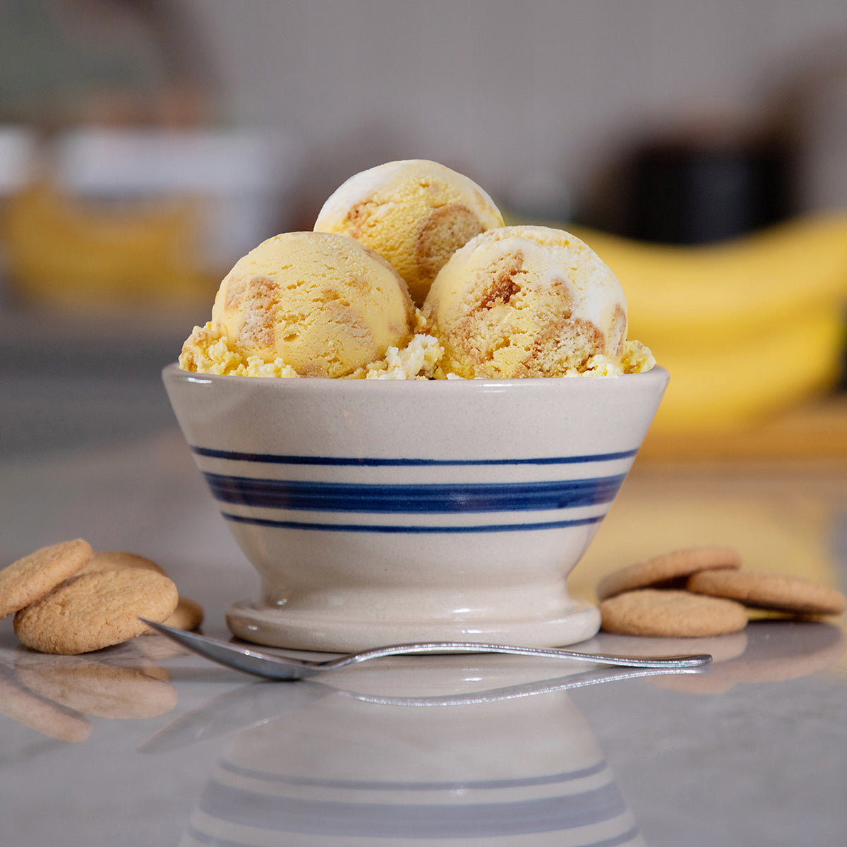 Blue Bell Banana Pudding Ice Cream in a bowl with vanilla wafers and a spoon