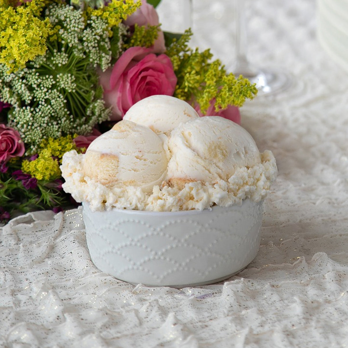 Bowl of Blue Bell Bride's Cake Ice Cream with a bouquet of flowers 