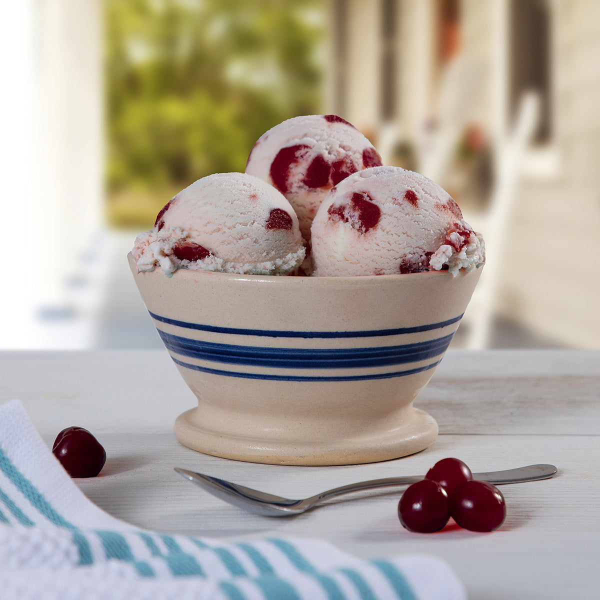 Blue Bell Cherry Vanilla Ice Cream in a bowl with cherries and a spoon