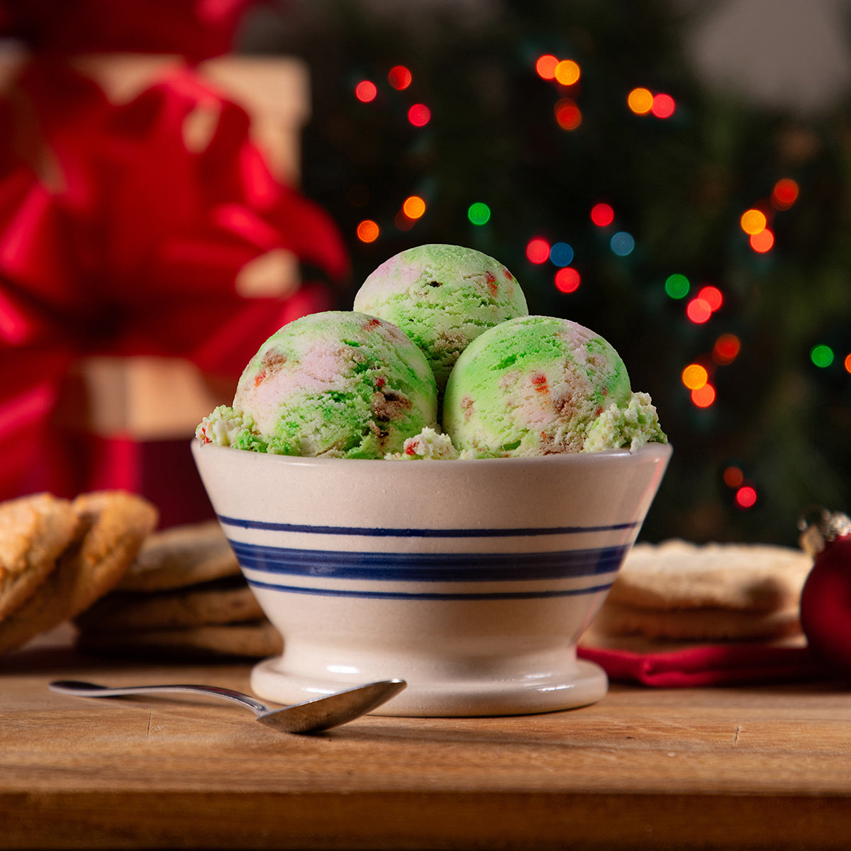 Bowl of Blue Bell Christmas Cookies Ice Cream with a holiday background and a spoon 