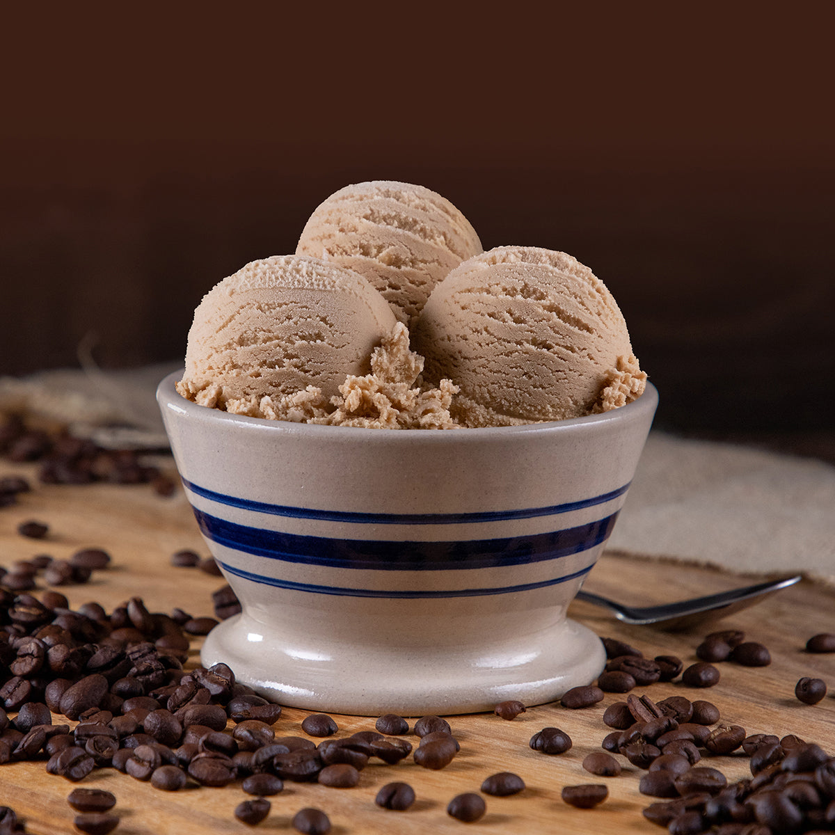 Bowl of Blue Bell Coffee Ice Cream with coffee beans and a spoon