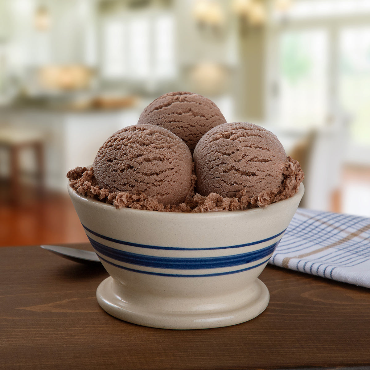 Bowl Blue Bell Dutch Chocolate Ice Cream on a wooden table in a kitchen setting