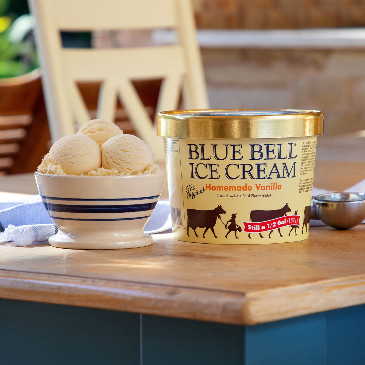 Blue Bell Homemade Vanilla ice cream container with a bowl of vanilla ice cream on a wooden table.